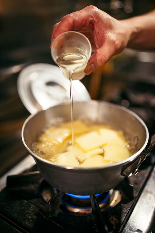 １０分くらいしてじゃがいもが少し柔らかくなったら、チーズを入れる。そこにサラダ油も入れ、再び弱火に５分程度かける。